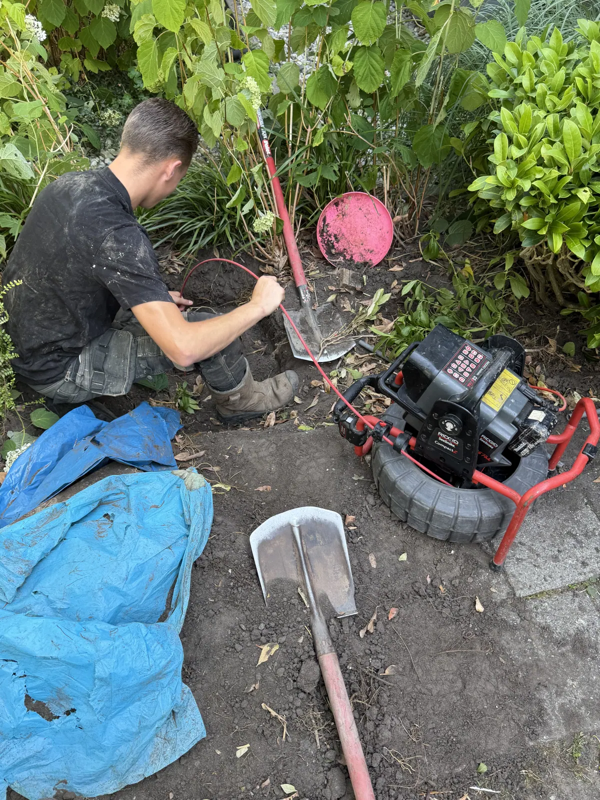 Monteur voert camera-inspectie uit in de tuin
